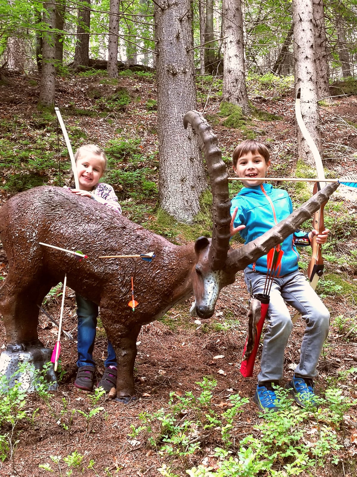 Kinder mit Bogen bei einem 3D-Ziel im Waldparcours der Bogensportarena Velden